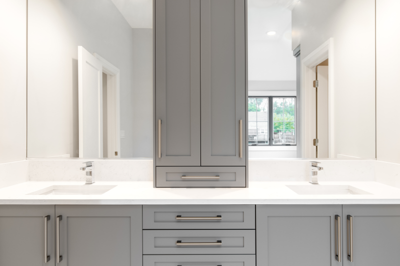 Completed grey cabinetry, showcasing a large vanity in a modern-style bathroom.