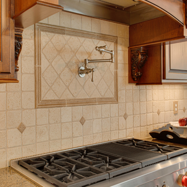  Luxurious kitchen stove area featuring high-end fixtures such as a wall-mounted pot filler.