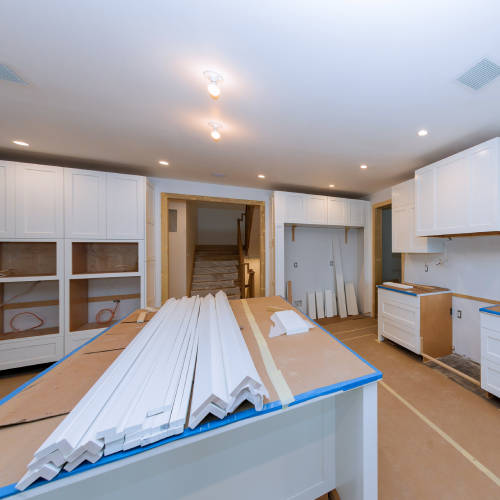 Installing new modern kitchen cabinets and a base for island in center.