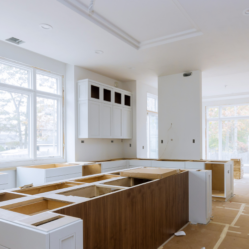A kitchen in the middle of a remodel. Open space concept featuring white and deep wooden cabinets in a light and bright kitchen.<br />

