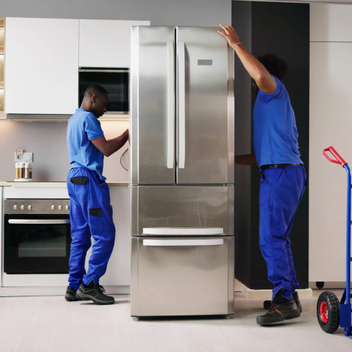 Two workers replace a fridge during kitchen remodel.